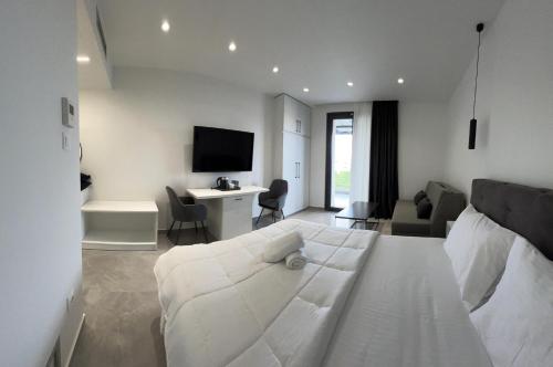 a bedroom with a white bed and a living room at Eleva Deluxe in Kastoria