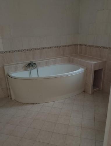 a bath tub in a bathroom with a tiled floor at Domek u lesa in Wamberg