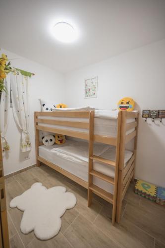 a childs bedroom with two bunk beds and a rug at Konak Lecic in TrÅ¡iÄ‡