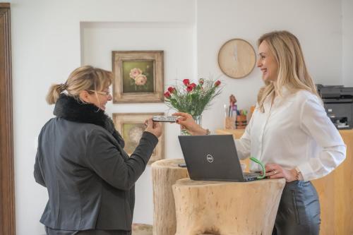 two women standing in a room with a laptop at Konak Lecic in TrÅ¡iÄ‡