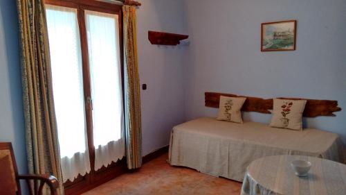 a room with a bed and a table and a window at Casa Rural Aristondo Agroturismo in Donostia-San Sebastián