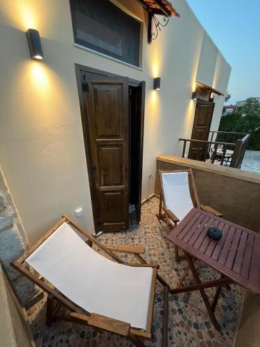 a balcony with two chairs and a table and a door at Mirodaty's House in Rhodes Town