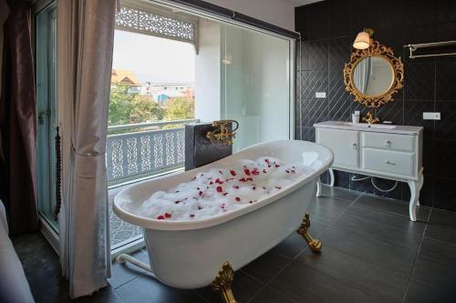 チェンマイにあるNidhra Lanna Hotel Chiang Maiのバスルーム(花の咲くバスタブ付)