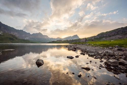 a view of a river with mountains in the background at Berghotel Distelboden in Frutt