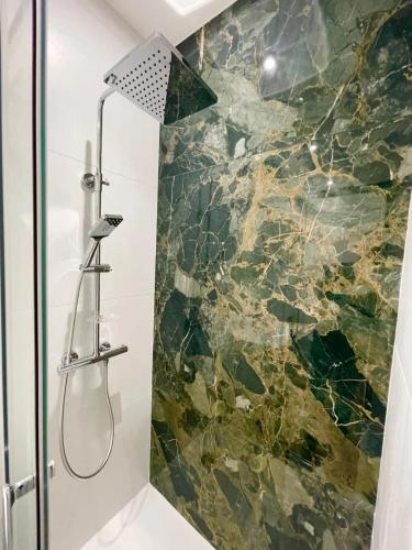 La salle de bains est pourvue d'une douche et d'un mur en pierre. dans l'établissement Climatisation, Ascenseur R5 Sublime T2 tout neuf, à Toulouse