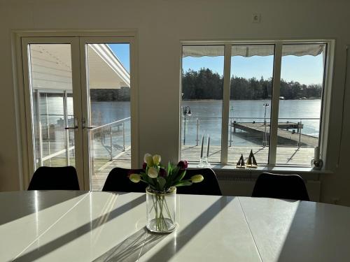 a vase of flowers on a table with a view of a dock at Villa Solsa in Nynäshamn