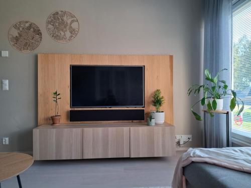 a living room with a flat screen tv on a cabinet at Local Home Kangas in Rovaniemi
