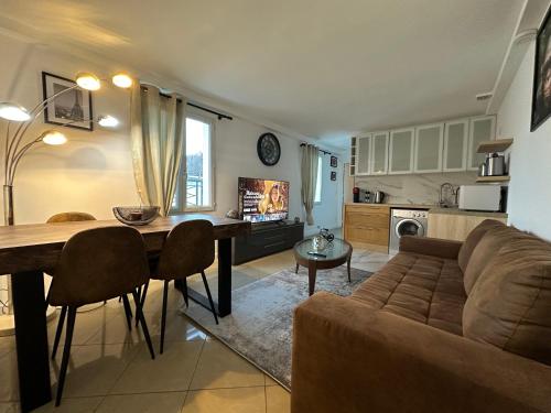 une cuisine et un salon avec un canapé et une table dans l'établissement Appartement khezia, à Champigny-sur-Marne