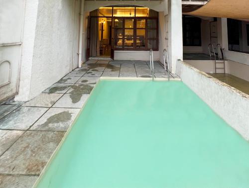 an empty swimming pool in front of a building at Avhyay Resort in Māndvi