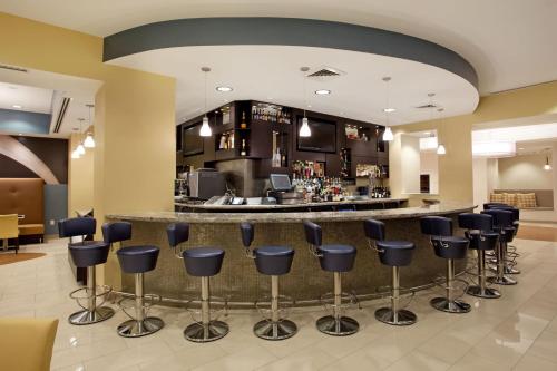 a lobby with a bar with blue bar stools at Hotel Indigo Baton Rouge Downtown by IHG in Baton Rouge
