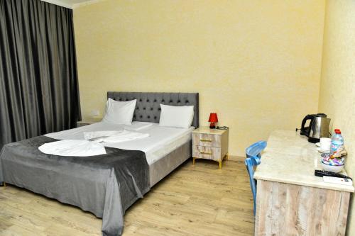 a bedroom with a large bed and a table at Avrasya Inn Hotel in Baku