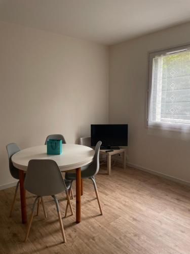 une pièce avec une table, des chaises et une télévision dans l'établissement Studio en plein centre-ville, au Puy-en-Velay