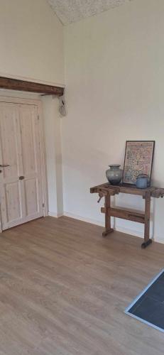 a room with a table and a painting and a door at Groennebaek Bed and Breakfast in Føvling
