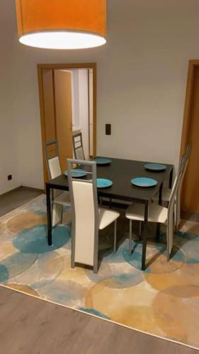 a dining room with a black table and chairs at NEU Ferienwohnung im Naherholungs u Seengebiet in Bruck in der Oberpfalz