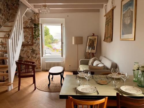 a living room with a table and a couch at Appartement vue Loire - Chez Lulu la Nantaise in Rezé