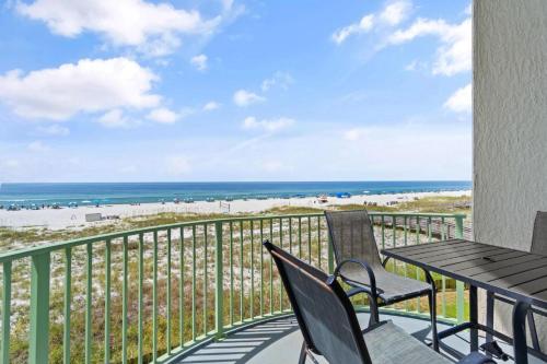 a balcony with a table and chairs and the beach at Perdido Towers West 307 in Perdido Key