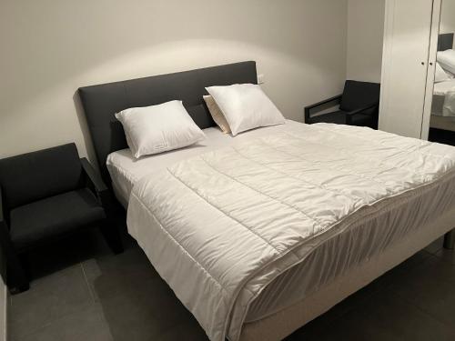 un lit avec deux oreillers et une chaise dans une chambre dans l'établissement Chapelle, à Mimizan-Plage