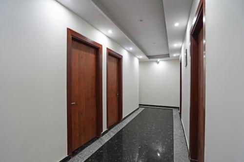 un pasillo con puertas de madera y una habitación en Hotel O Noida Stays, en Indirapuram
