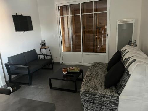 un salon avec un canapé et une chaise dans l'établissement Chapelle, à Mimizan-Plage