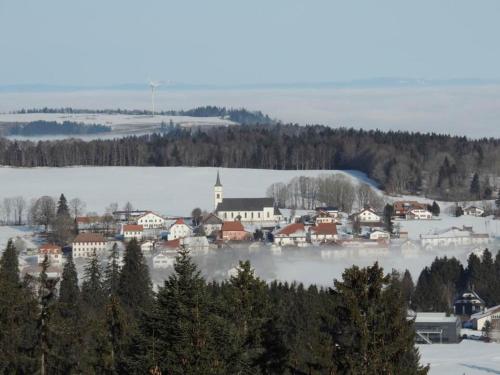 a small town in the snow with a church at Chambres d'hôtes in Les Genevez