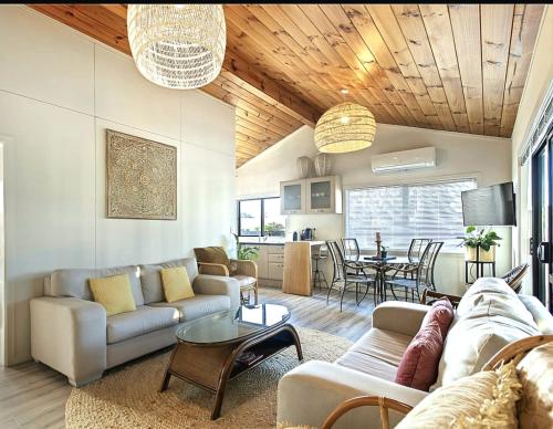a living room with a couch and a table at Ultimate Mount Location in Mount Maunganui