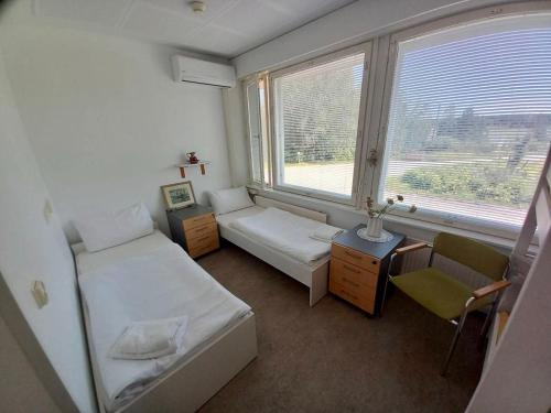 una piccola stanza con due letti e una finestra di Kampus Sippola a Sippola