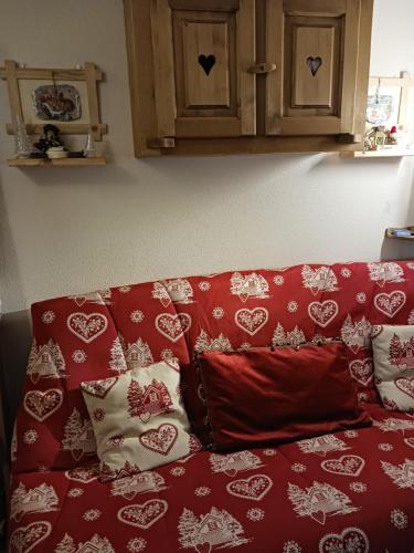 - un canapé rouge avec des oreillers rouges et blancs dans l'établissement La dent d'Oche, à Bernex