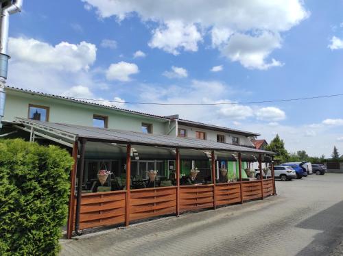 a building with a porch with chairs in a parking lot at Penzion a restaurace U Knoppa in Opava