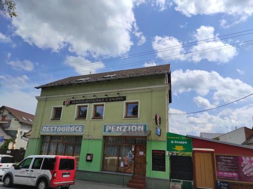 a building on a street with a van parked in front at Penzion a restaurace U Knoppa in Opava