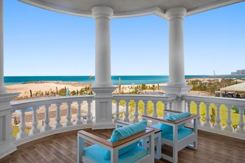 a balcony with chairs and a view of the beach at Gewan Palace New Alamein in El Alamein