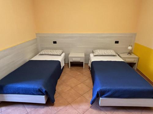 two beds in a room with yellow walls at B&B Molinetto in Piacenza