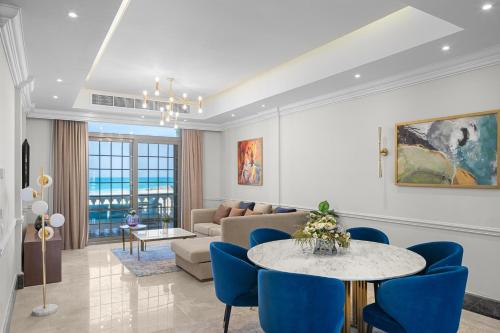 a living room with a table and blue chairs at Gewan Palace New Alamein in El Alamein