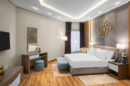 a hotel room with a bed and a television at Gewan Palace New Alamein in El Alamein