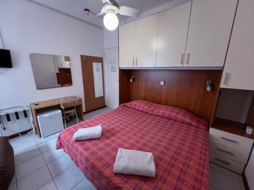 a bedroom with a bed with two towels on it at Hotel Zen in Lignano Sabbiadoro