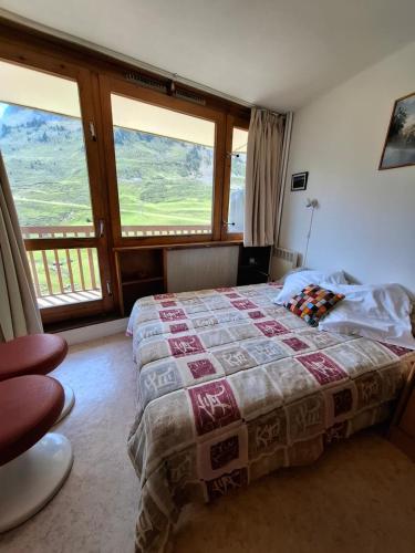 une chambre avec un lit et une grande fenêtre dans l'établissement Mongie Appart, à Bagnères-de-Bigorre