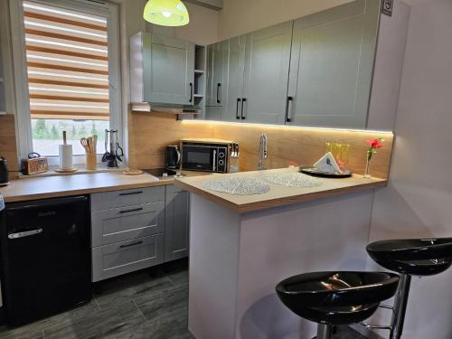a kitchen with a counter and two stools at Noclegi -Chata Polska in Chrostkowo