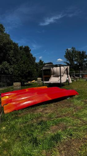 a red kayak laying on the grass in a field at Ośrodek u Polaka-domek góralski in Radkowice