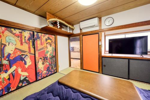 a living room with a table and a tv at 慶村 歌舞伎 in Fujikawaguchiko