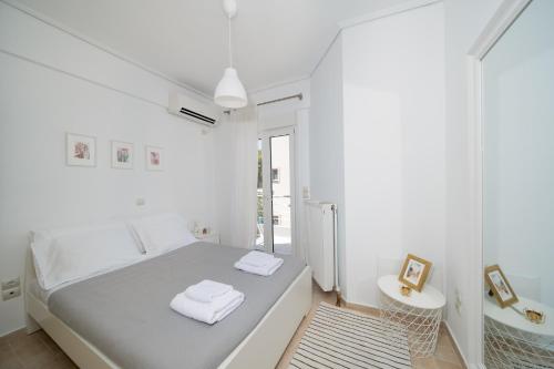 a white bedroom with a bed and a mirror at Apollonian villa in Artemida