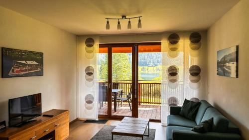 a living room with a couch and a television at Premium Apartments am Weißensee in Weissensee
