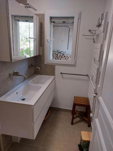 une salle de bain blanche avec un lavabo et une fenêtre dans l'établissement Haus im Naturpark Luberon, à Grambois