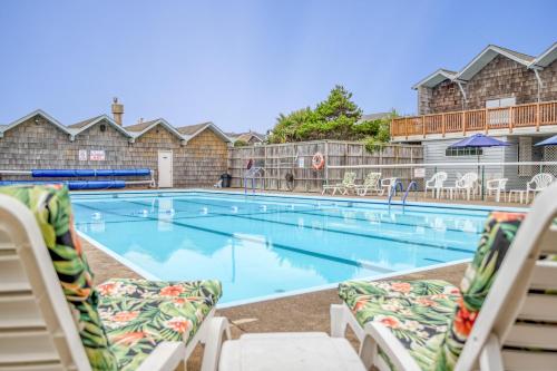 a swimming pool with chaise lounge chairs in a hotel at Sand and Sky in Bayshore