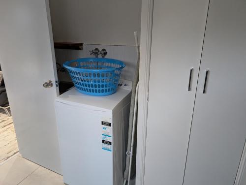 a blue bowl sitting on top of a refrigerator at Behind the hedge in Tenterfield