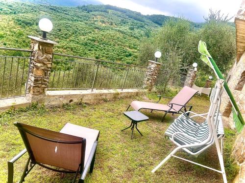 a group of chairs sitting on top of a balcony at Casa Vacanza Paola Aurigo in Aurigo