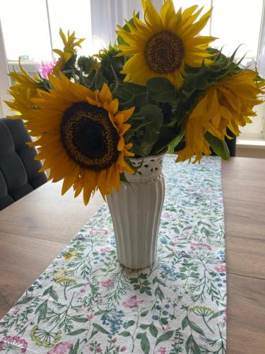 a vase filled with sunflowers sitting on a table at Dworek pod Krzyżtoporem Ujazd Agroturystyka- pokoje do wynajęcia in Iwaniska