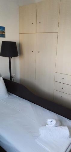 a bed with a black lamp and a white towel on it at Maria’s Sunset House in Megalochori