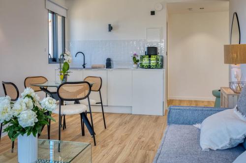 a living room with a table and a kitchen at Vue mer - Appartement Aquamoon AuraPlage in Roquebrune-sur-Argens