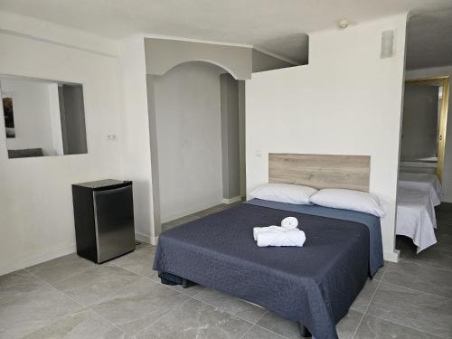 a bedroom with a bed with a white towel on it at Hotel Velis in Vélez-Málaga