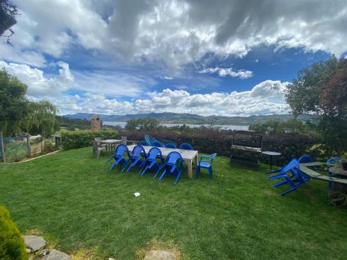a group of blue chairs and a table on a lawn at Chalet Amadeus Guatavita in Guatavita