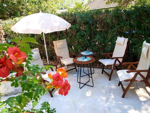 a patio with chairs and a table and an umbrella at Stone sea apartment in Risan